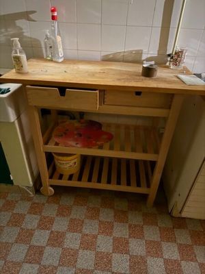 une cuisine équipée d'un évier et d'un plan de travail en bois