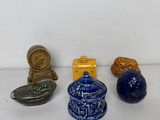 trois petits objets en céramique bleus et jaunes sont posés sur une surface blanche