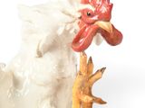 a white chicken with a red comb on its head