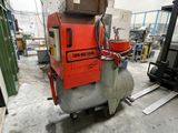 a red machine that is sitting in a warehouse