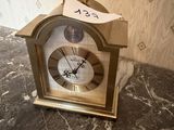 une petite horloge posée sur un plan de travail en marbre