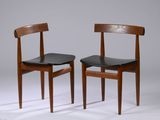 deux chaises en bois avec des assises en cuir noir sur fond gris