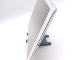 a tablet computer sitting on a stand on a white surface