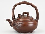 an image of a teapot with a handle and two birds on it