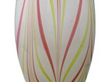 a white vase with a red, yellow, and green design on it