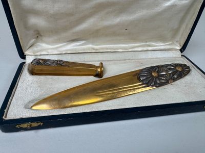 un couteau en or et un porte-couteau dans un étui