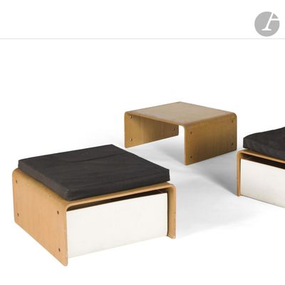 three stools and a table with a black cushion on them