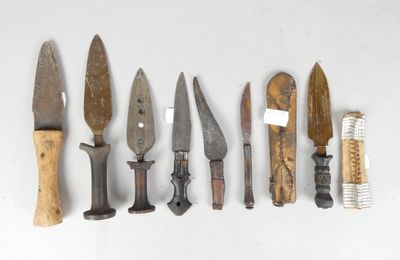 several different types of knives are lined up on a white surface