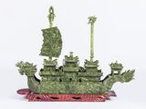 statue représentant un bateau vert orné d'un dragon à l'avant