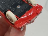 a person holding a red toy car that has wheels on it