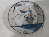 une assiette sur laquelle sont peints un oiseau et des fleurs