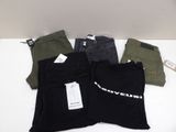three pairs of black, green, and grey pants with tags on them