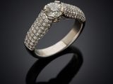 a white gold ring with diamonds on a black background