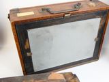 an old wooden suitcase with a mirror on top of it