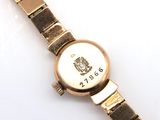 a gold wrist watch with a crest on it