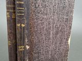 un vieux livre posé sur une table à côté d'un autre livre