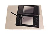 a black nintendo wii game console with a pen on top of it