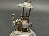 statue of a man riding an elephant with a man on top of it