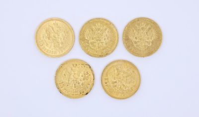 quatre pièces d'or superposées sur une surface blanche