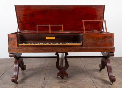 an old piano sitting on top of a wooden table