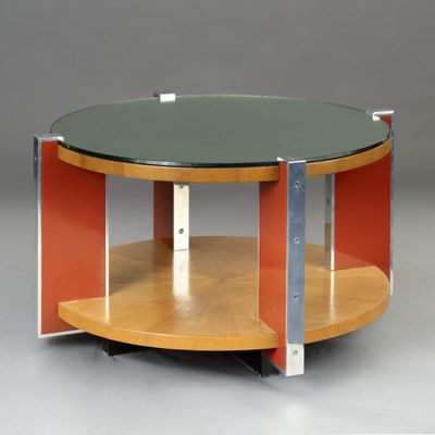 une table ronde avec un plateau en verre et des pieds en métal