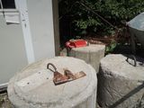 deux piliers en béton sur lesquels est fixée une poignée métallique rouillée