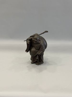 figurine of a man with a stick in his hand on a white surface
