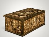 an ornate gold box with carvings on it on a white background