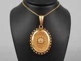 un collier en or avec un médaillon sur un mannequin noir