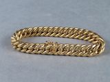 a close up of a gold bracelet on a gray surface