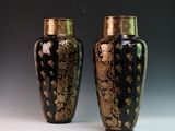 pair of black and gold vases sitting on top of a table