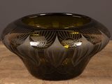 a black vase sitting on top of a wooden table