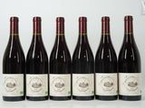 six bouteilles de vin sont alignées sur une table