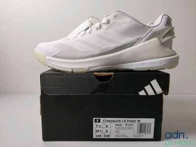 Des chaussures adidas dans une boîte posée sur une surface blanche