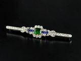 a close up of a green and white sapphire and diamond broochle