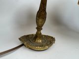 a gold lamp that is sitting on a white table