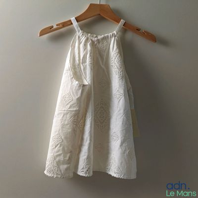 une robe blanche suspendue à un cintre accroché au mur