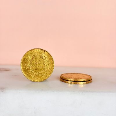 two gold coins sitting on top of a marble counter top