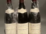 three bottles of wine wrapped in plastic sitting on a table