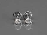 une paire de boucles d'oreilles en diamant posées sur une surface réfléchissante