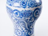 a blue and white vase sitting on a white surface
