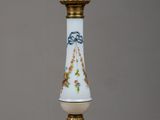 un vase blanc avec un socle doré posé sur une table