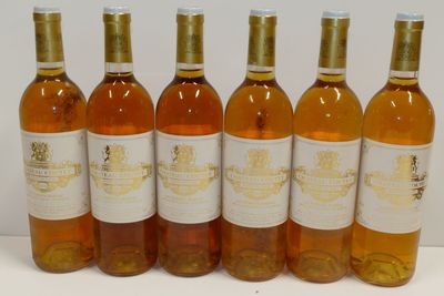 six bouteilles de vin sont alignées sur une surface blanche