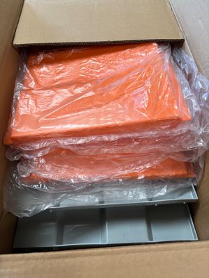 a cardboard box filled with orange sheets and plastic