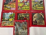 six livres pour enfants à la couverture rouge posés sur une table blanche