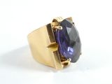 une image représentant une bague en or sertie d'une pierre violette