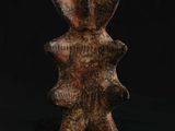 une sculpture en bois représentant un homme, avec sa tête, sur fond noir