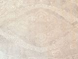 an old white table cloth with a paisley design on it