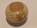 a brown and white vase sitting on a white table