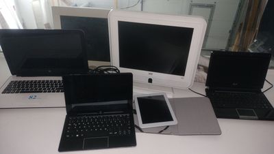 trois ordinateurs portables et un téléphone portable posés sur un bureau